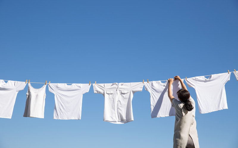 写真：青空の下で洗濯物を干す様子