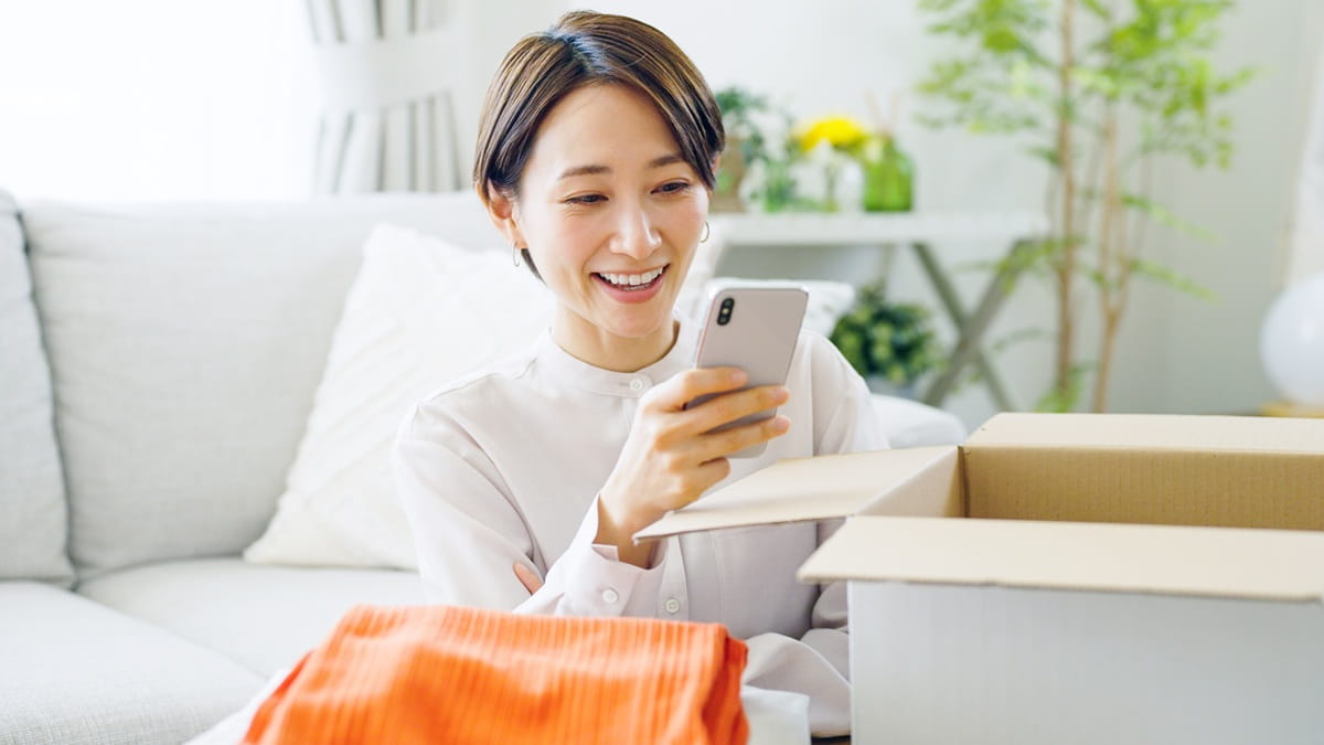 引越し作業中にスマートフォンを操作する女性のイメージ